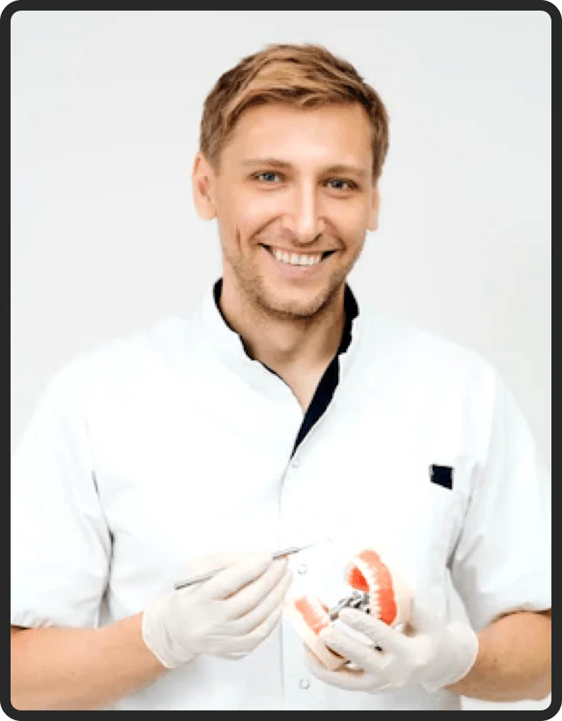 Dentista sorrindo segurando um modelo de arcada dentária